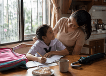 Filipino mom and child at home during a rainy school day